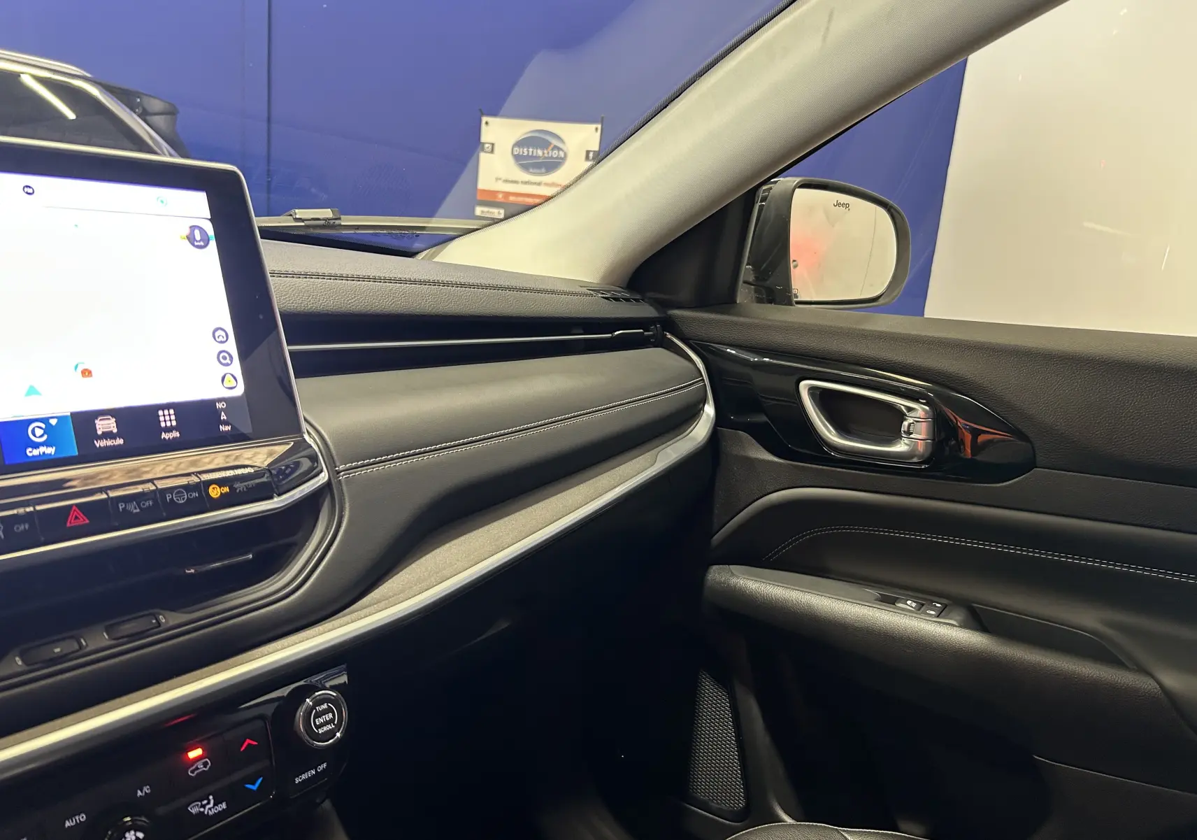 Intérieur du Jeep Compass Limited 2021, vue côté passager avec tableau de bord noir et écran tactile allumé.