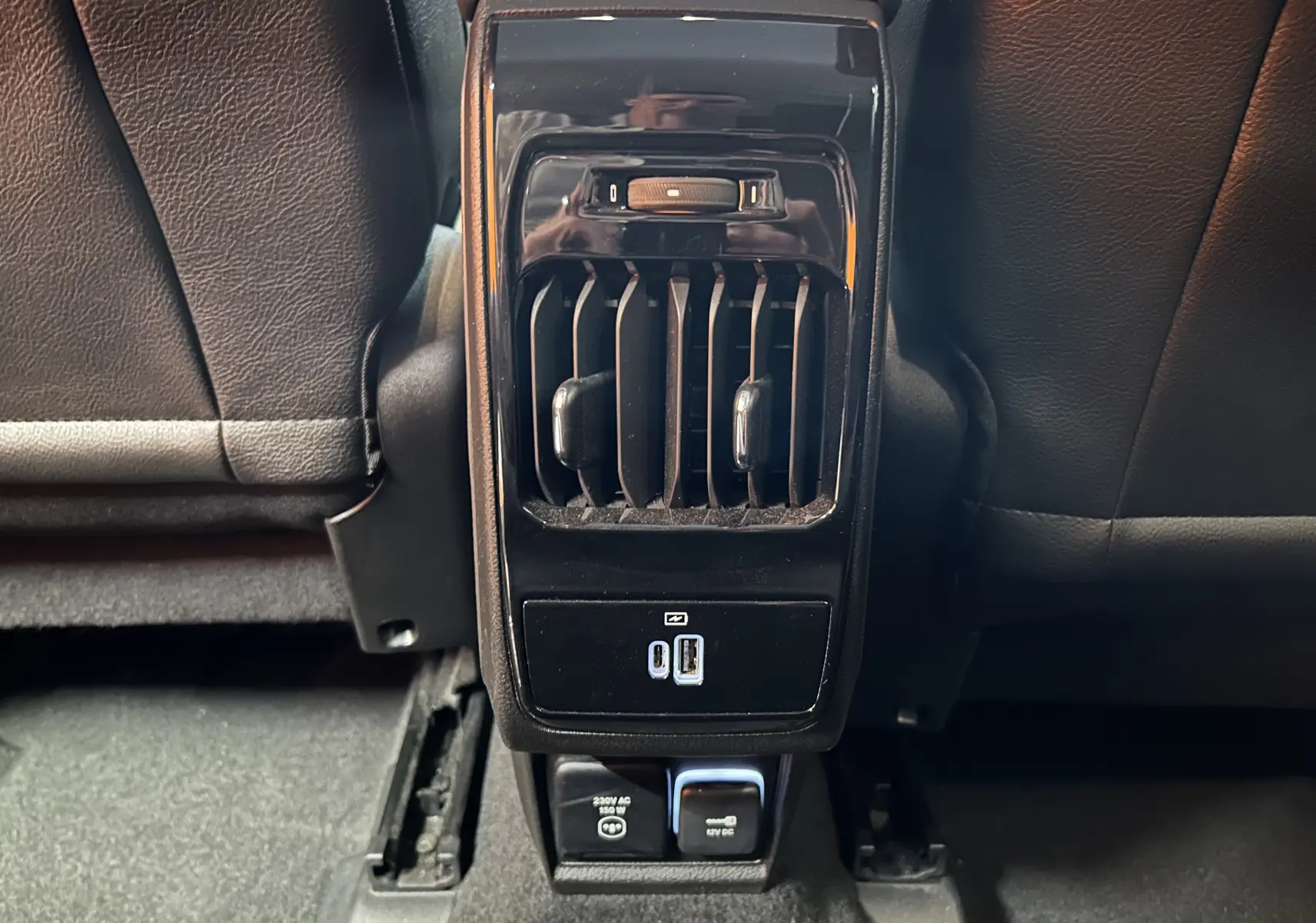 Gros plan sur la console arrière noire du Jeep Compass Limited 2021, avec bouches d’aération et ports USB visibles.