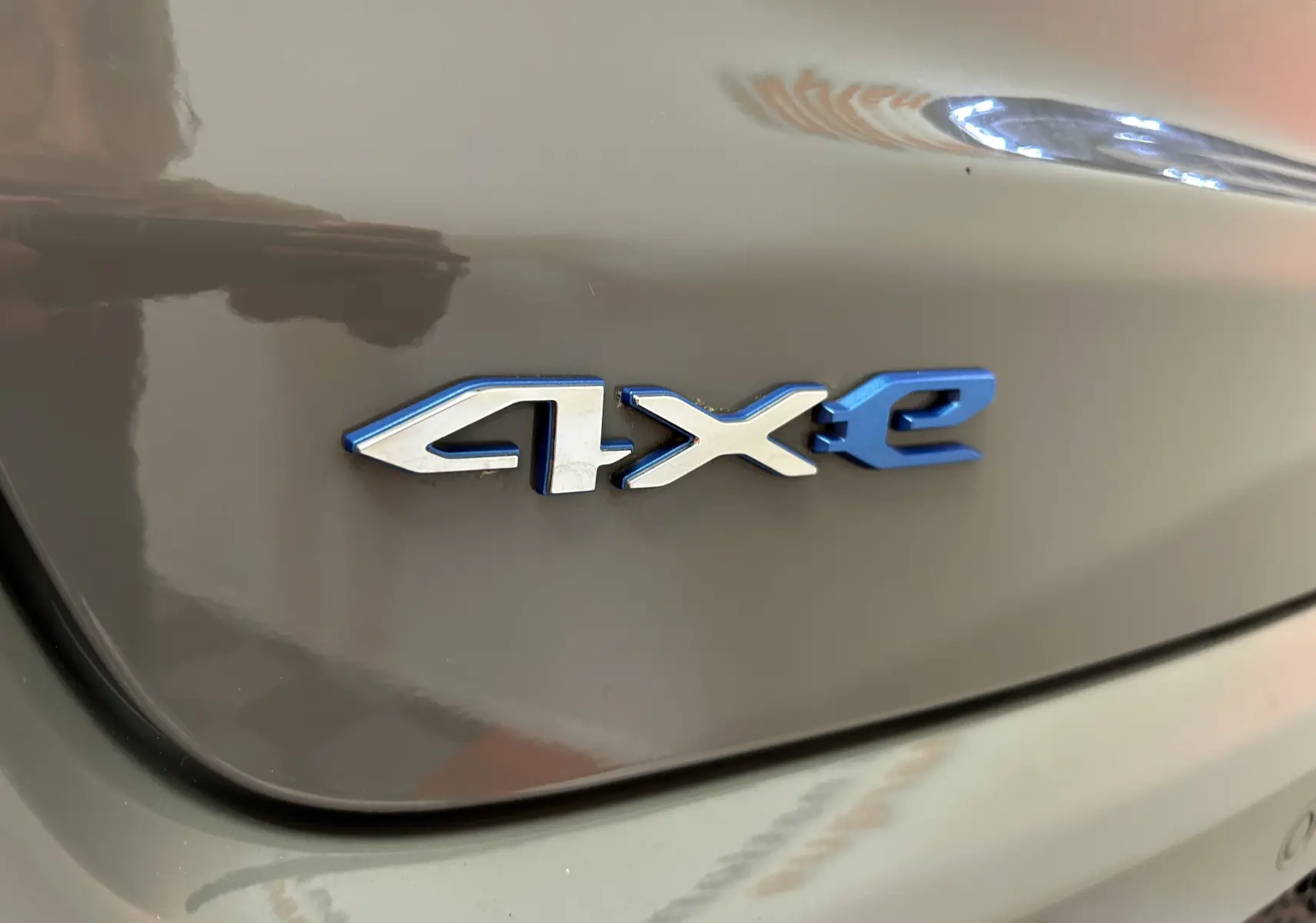 Gros plan sur l'emblème 4xe bleu et argent du coffre arrière gris du Jeep Compass Limited 2021 hybride rechargeable.