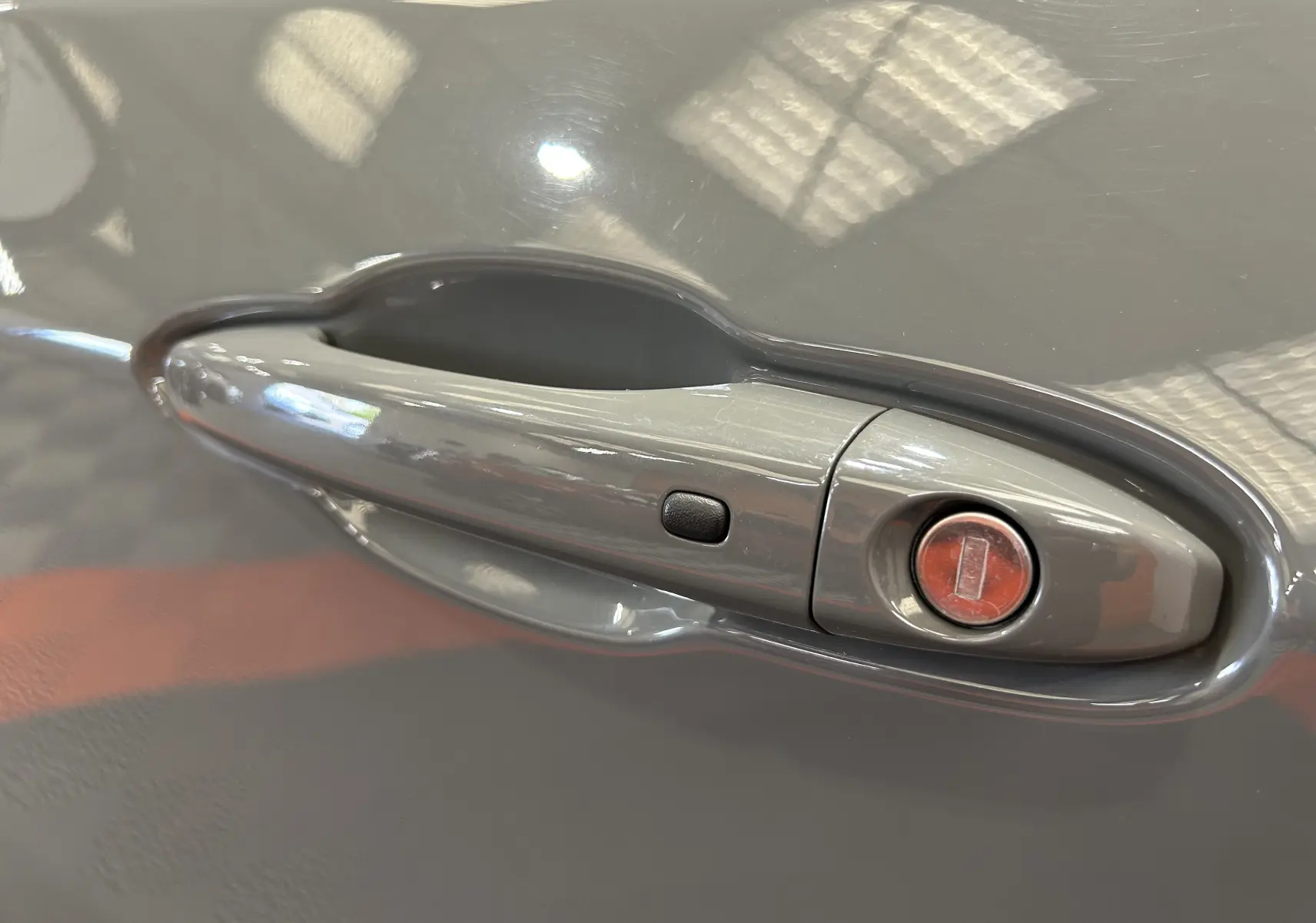 Poignée de porte grise en gros plan sur Jeep Compass Limited 2021, avec bouton de verrouillage intégré.