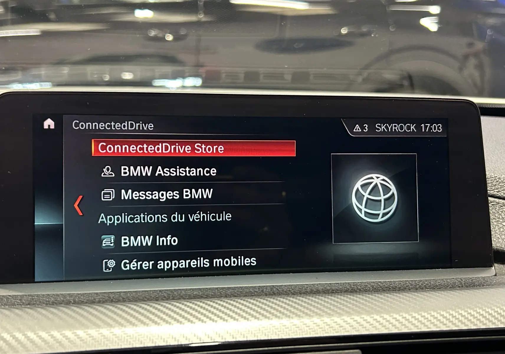 Écran central du système BMW ConnectedDrive affichant le menu principal dans l’habitacle d’une BMW Série 3 blanche.