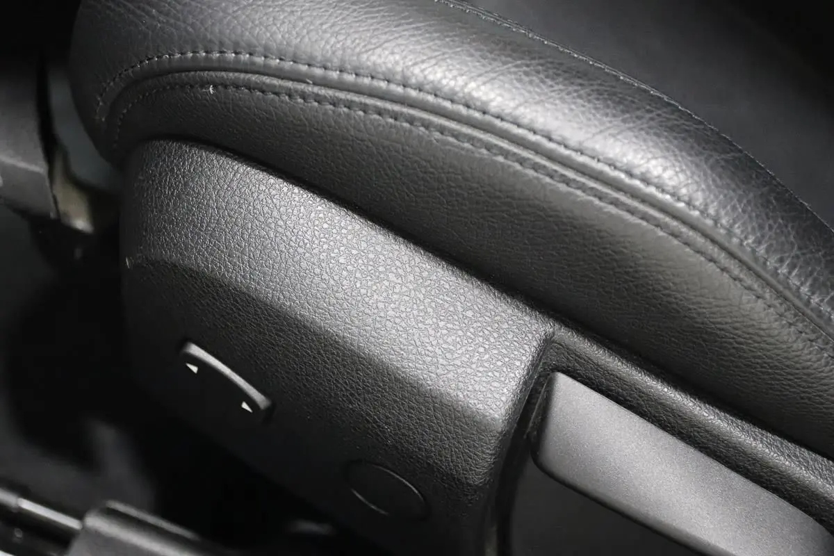 Gros plan sur la commande de réglage électrique du siège en cuir noir de la BMW Série 3 320i 2018.