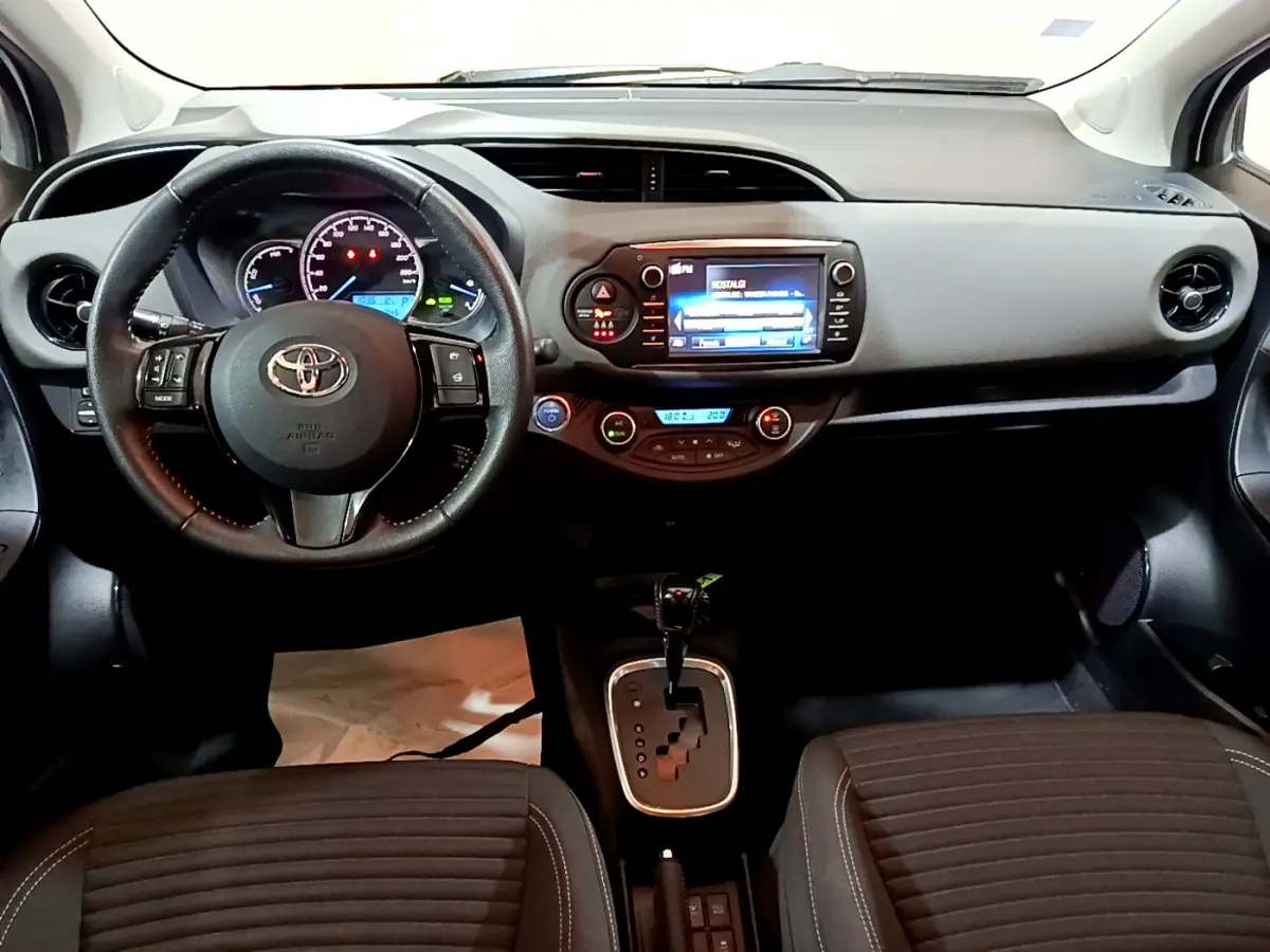 Tableau de bord et console centrale de la Toyota Yaris blanche 2020, vue frontale intérieure avec écran tactile et volant cuir.