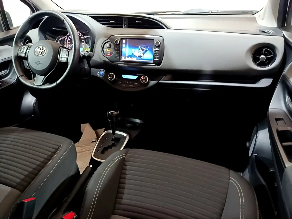 Intérieur de la Toyota Yaris 1.5 Hybride 2020, vue de face côté conducteur, tableau de bord noir avec écran tactile central.