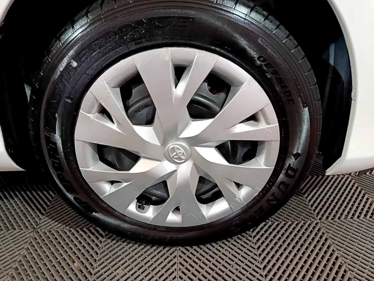 Gros plan sur la roue avant droite blanche d'une Toyota Yaris 1.5 Hybride avec jante en alliage et pneu Dunlop.