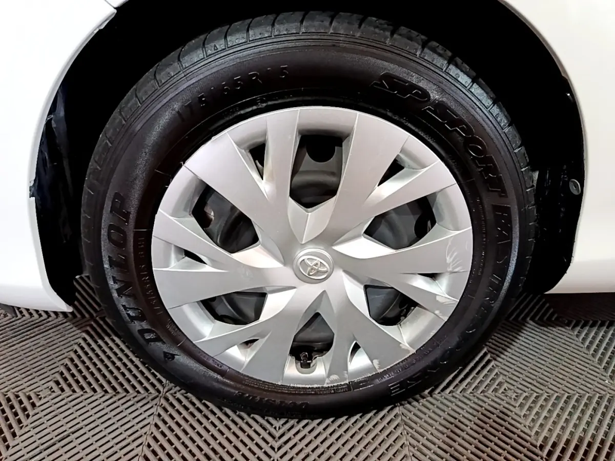 Gros plan sur la roue avant droite blanche d'une Toyota Yaris 1.5 Hybride 2020 avec jante en alliage argenté.