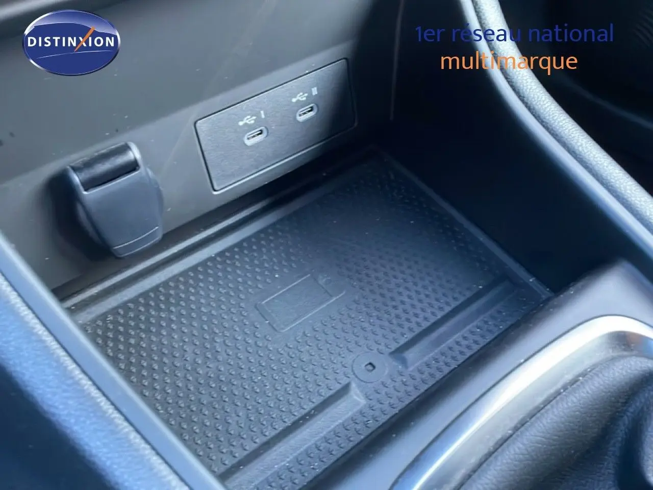 Gros plan sur le compartiment central noir avec ports USB et surface antidérapante du Renault Captur rouge toit noir.