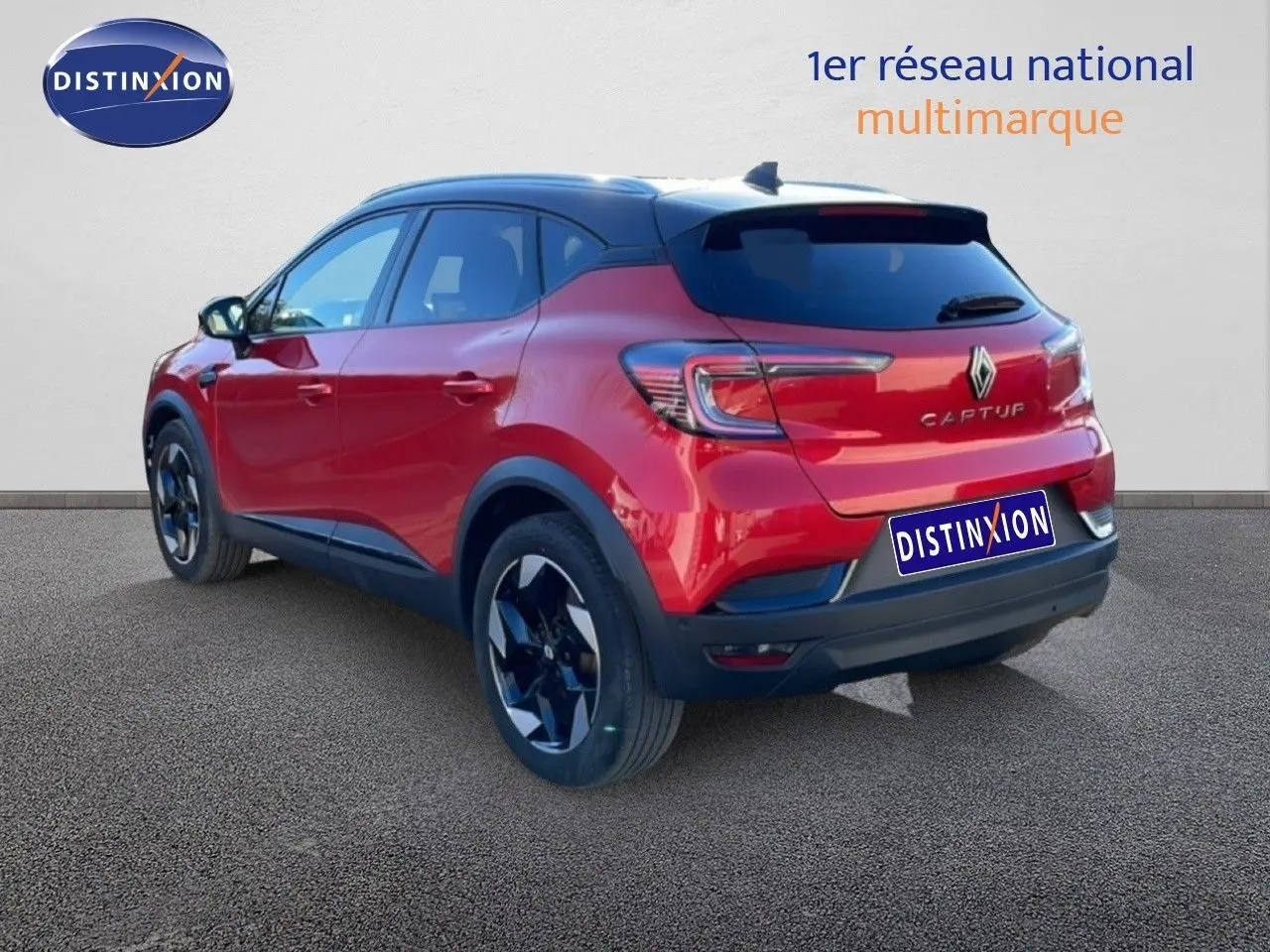 Vue 3/4 arrière droite d'un Renault Captur rouge désir métal avec toit noir et jantes bicolores.