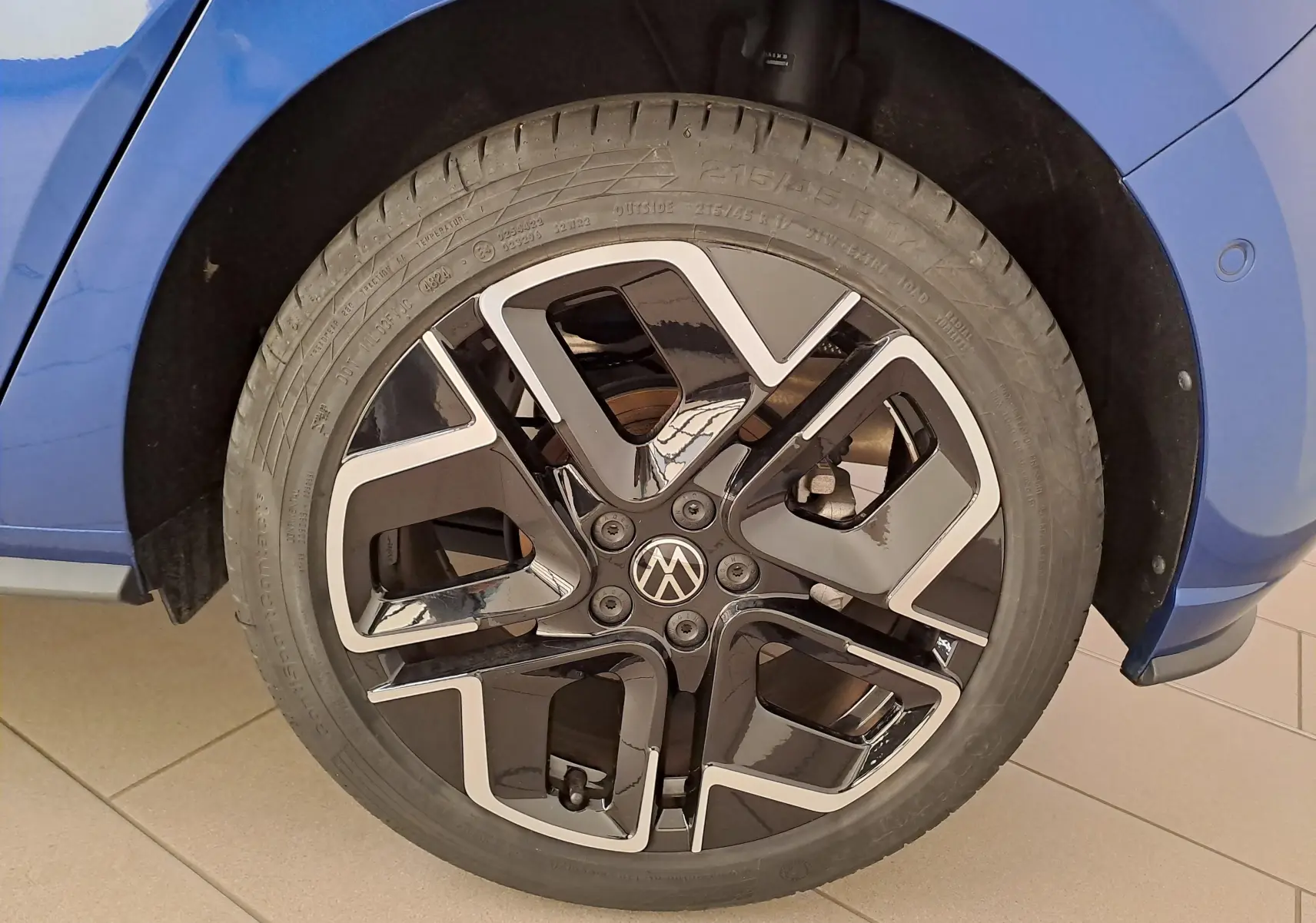 Gros plan sur la roue avant droite de la Volkswagen Polo Bleu Récif avec jante alliage noir et argentée au design R-Line.