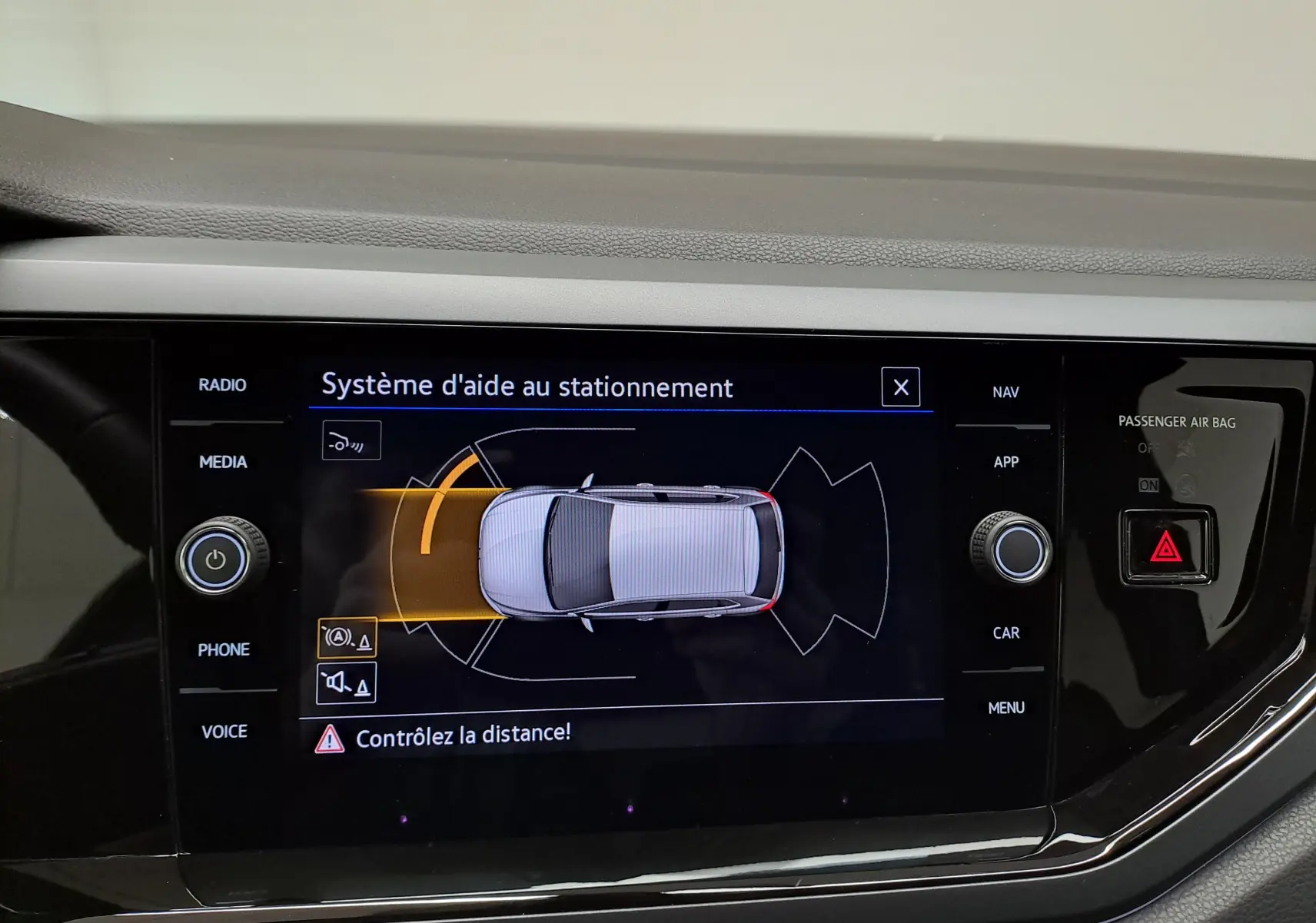 Écran tactile intérieur montrant le système d'aide au stationnement de la Volkswagen Polo 2025 en vue de dessus du véhicule.