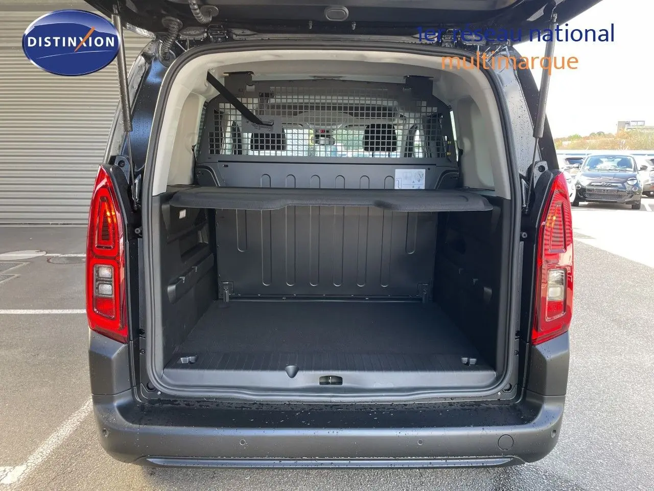 Vue arrière ouverte du Citroën Berlingo noir Perla Nera, montrant l’espace de chargement utilitaire avec cloison métallique.