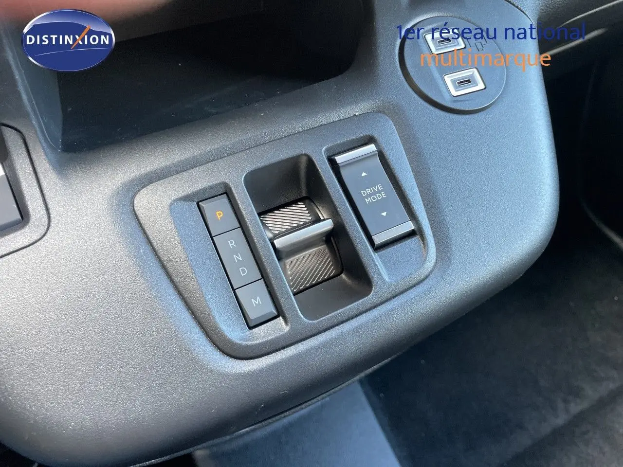 Gros plan sur la console centrale du Citroën Berlingo noir, montrant la commande de boîte auto et le sélecteur Drive Mode.