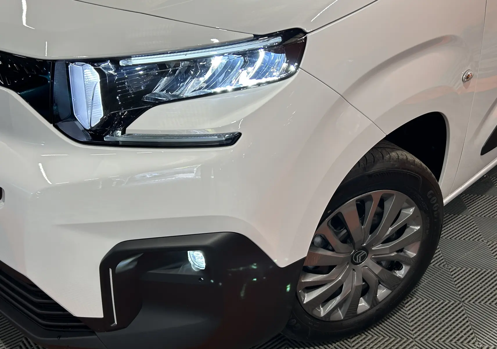 Gros plan sur l’avant droit blanc Kaolin du Citroën Berlingo Multispace 2026 avec phare LED et antibrouillard allumé.