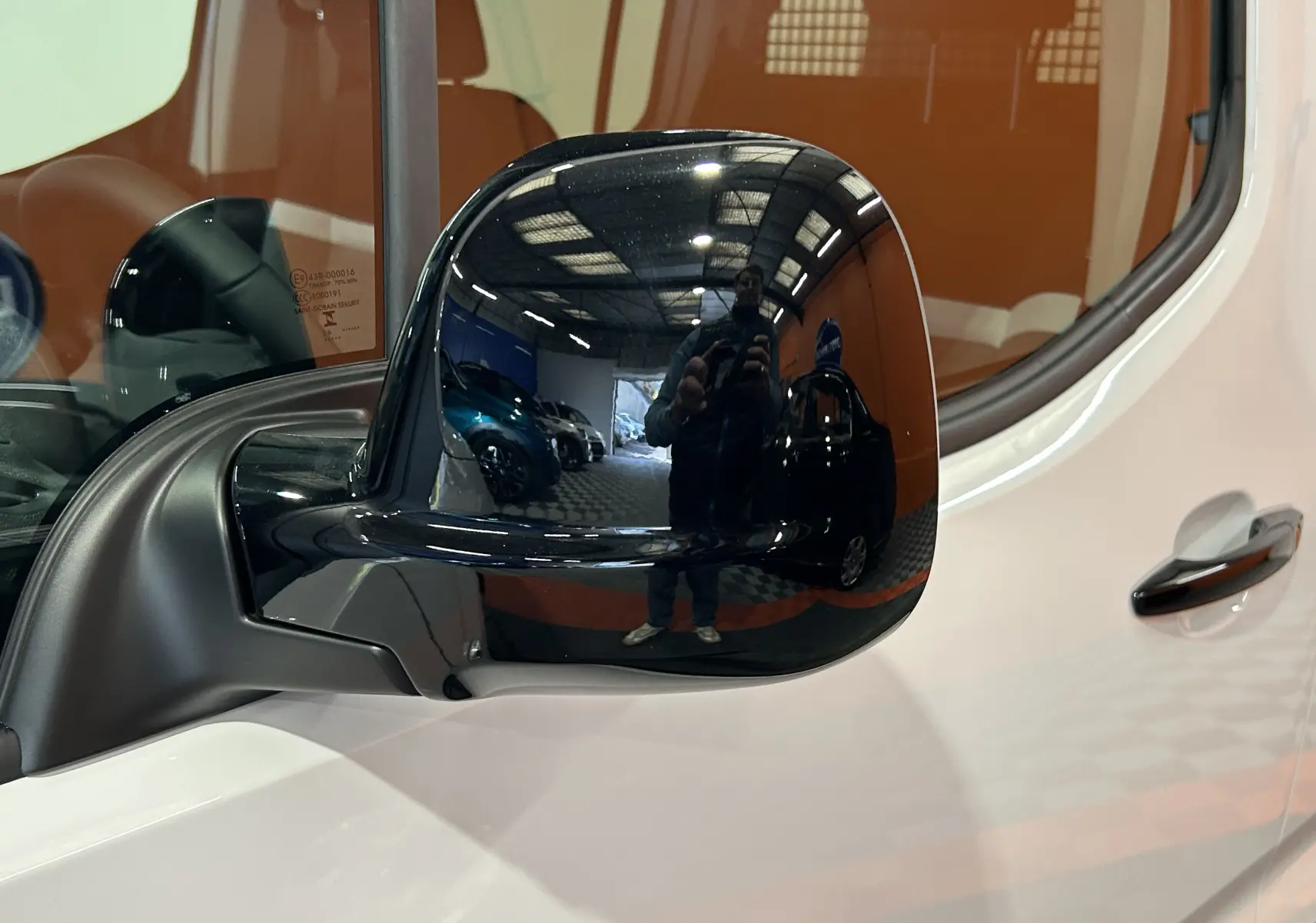 Rétroviseur latéral droit noir brillant sur Citroën Berlingo Multispace blanc Kaolin, vue rapprochée côté conducteur.