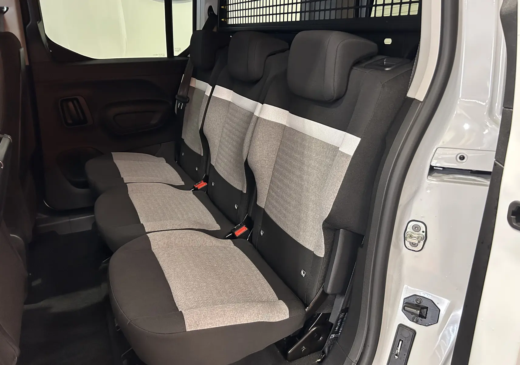 Vue latérale intérieure des trois sièges arrière en tissu gris et noir du Citroën Berlingo Multispace blanc Kaolin.