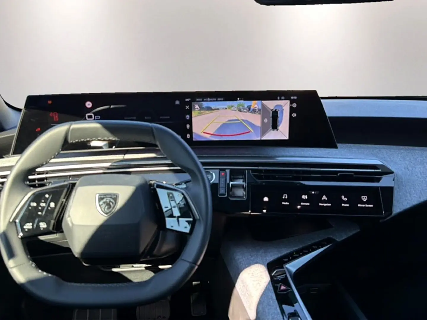 Vue intérieure centrée sur le volant cuir et l'écran tactile affichant la caméra de recul du Peugeot 3008.