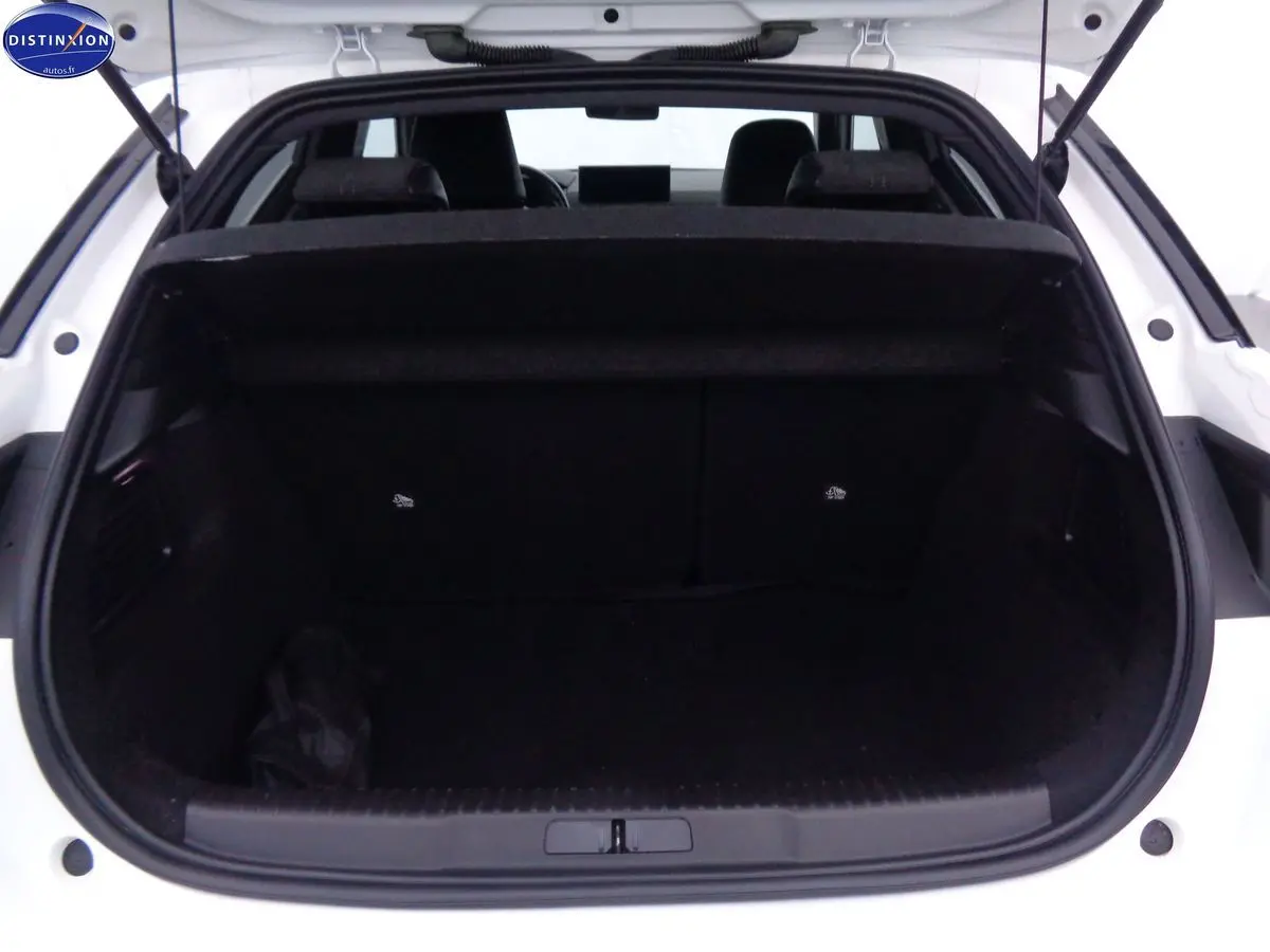 Coffre ouvert vu de l'arrière d'une DS3 Crossback blanc banquise, intérieur noir et banquette arrière visible.