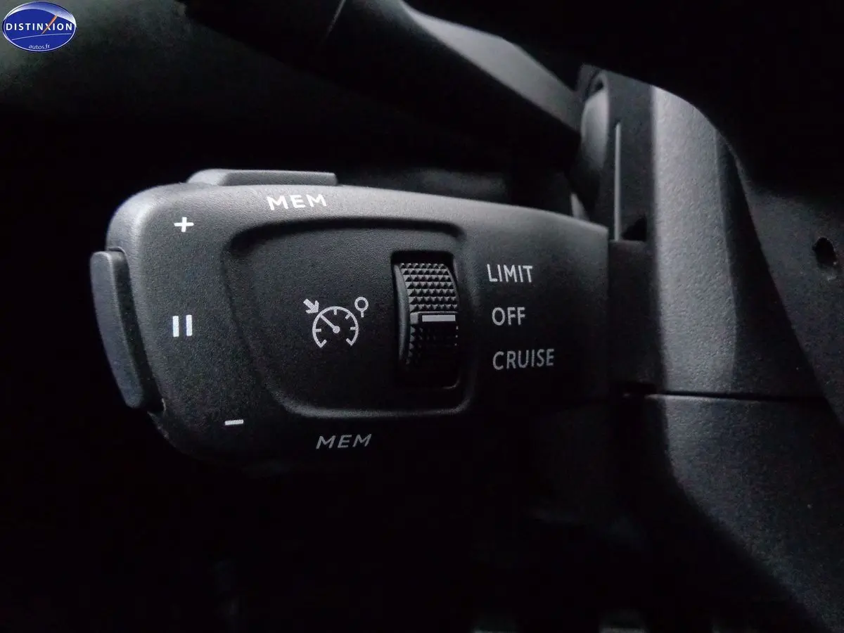 Gros plan sur la commande de régulateur de vitesse du DS3 Crossback blanc banquise, avec boutons MEM et sélecteur LIMIT/OFF/CRUISE.