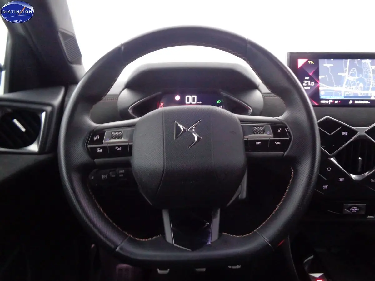 Vue rapprochée du volant en cuir noir du DS3 Crossback 2021 avec tableau de bord digital et écran tactile GPS.