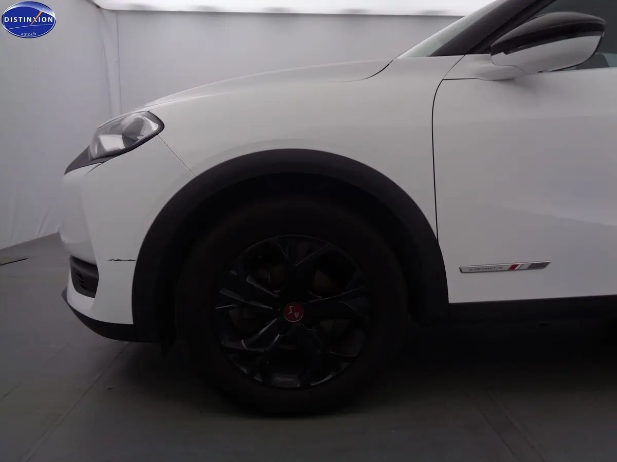 Vue de profil côté gauche sur l'avant blanc banquise du DS3 Crossback avec jante noire et badge Performance Line.