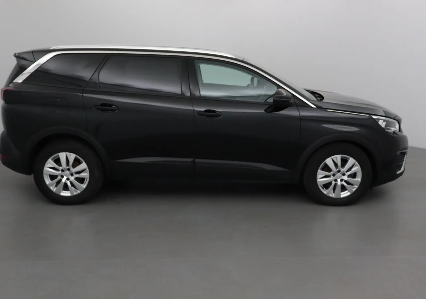 Profil côté droit d'un Peugeot 5008 noir 2019, SUV familial aux lignes épurées et jantes alliage argentées.