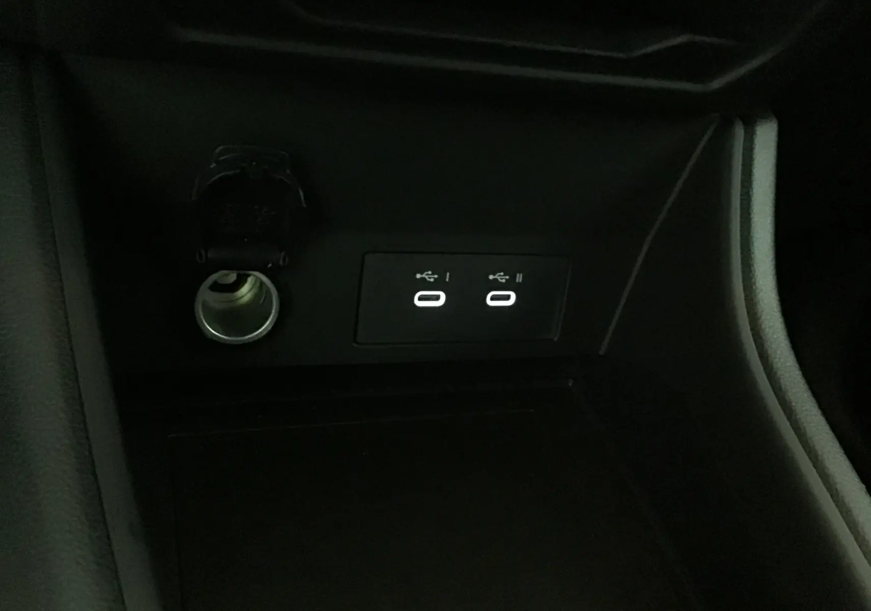 Prise allume-cigare et deux ports USB éclairés dans la console centrale du Renault Captur bleu iron/noir 2025.
