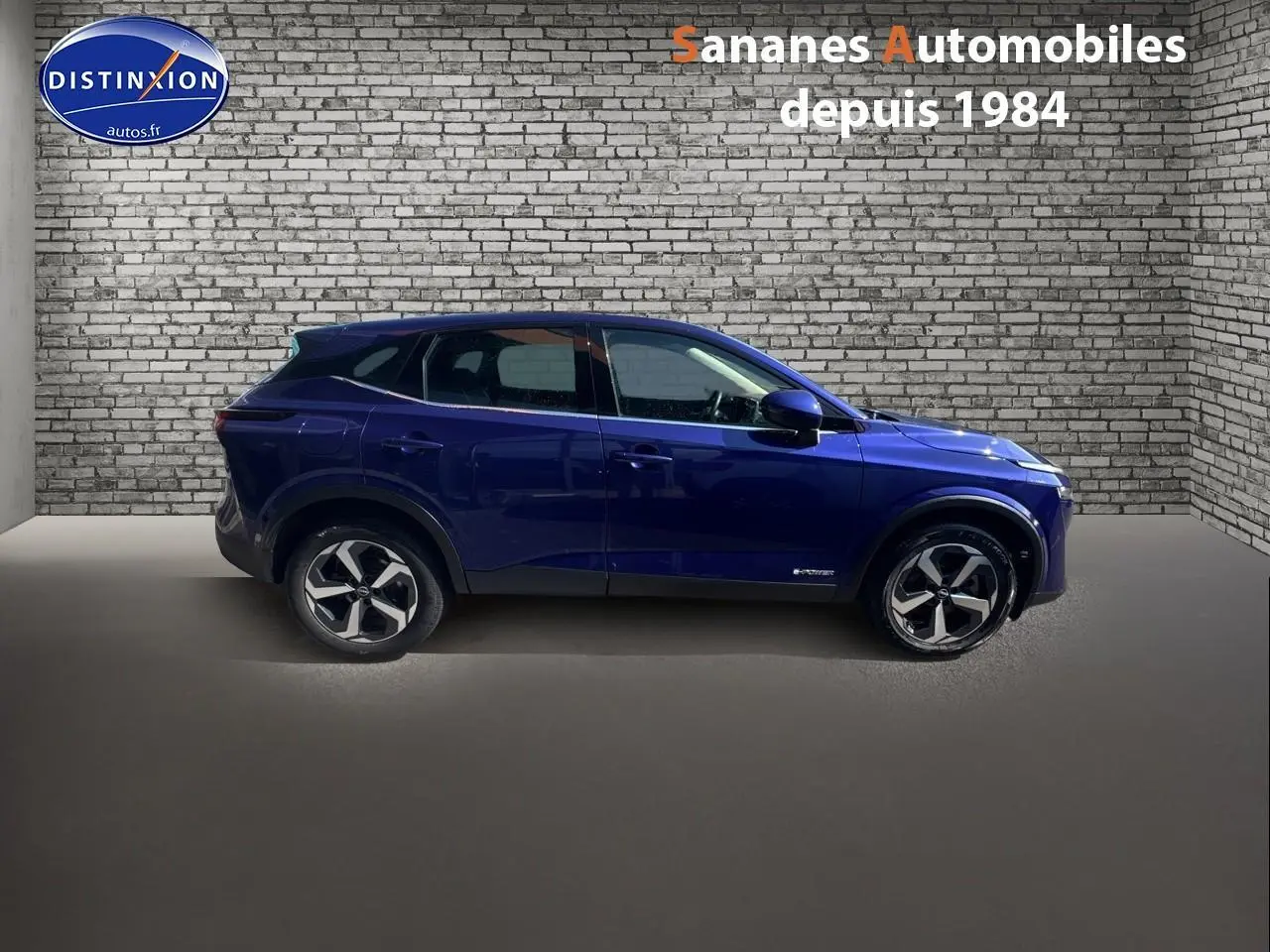 Profil côté gauche d'un Nissan Qashqai 1.5 e-Power Business Edition bleu foncé avec jantes alliage 18 pouces.