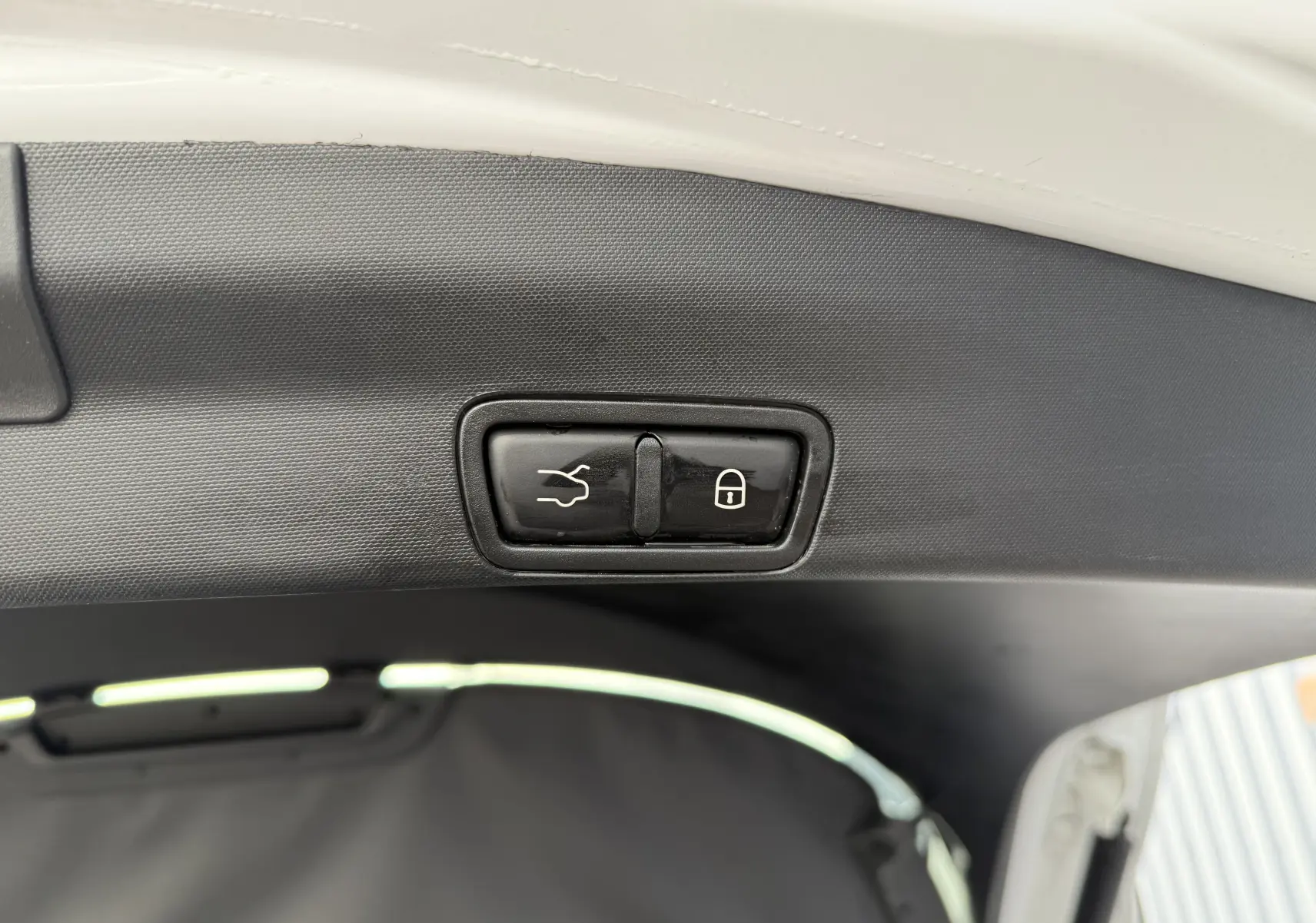 Boutons de fermeture et verrouillage électrique du hayon sur un Alfa Romeo Stelvio blanc 2023, vue intérieure du coffre.