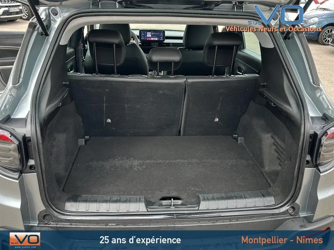 Coffre ouvert d'un Jeep Avenger gris foncé 2024, vue arrière montrant l'espace de chargement et les sièges arrière.