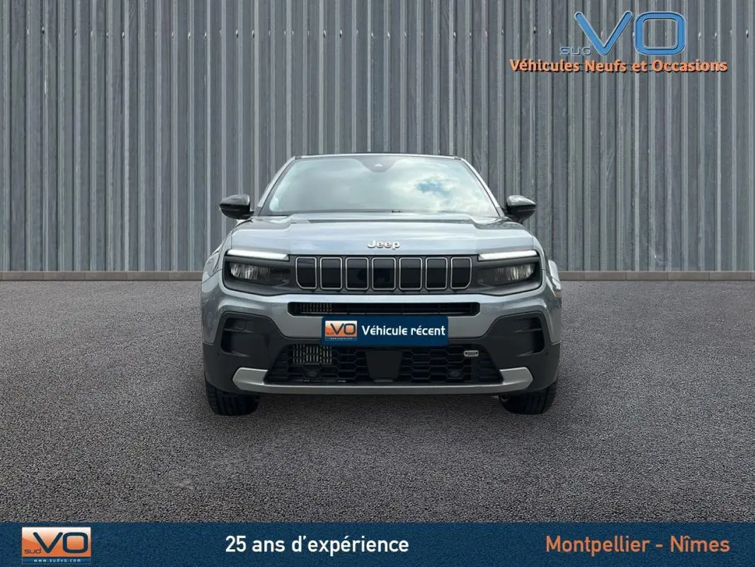 Vue frontale d'un Jeep Avenger gris foncé 2024 avec calandre distinctive et phares LED intégrés.
