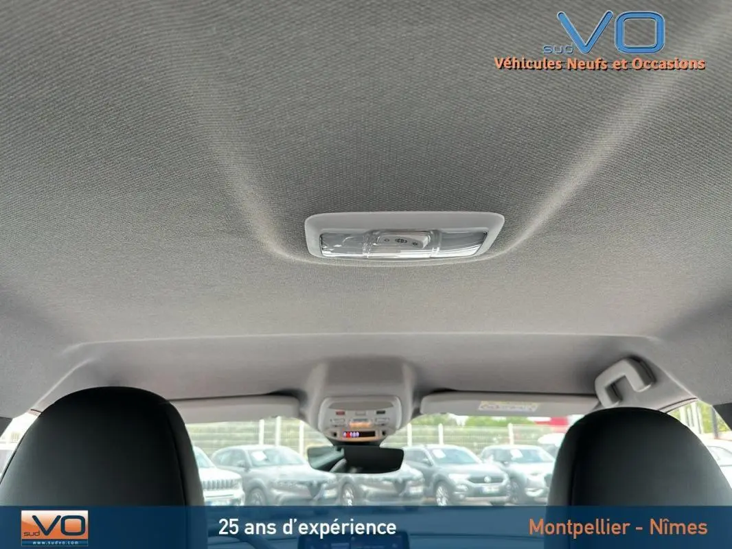 Vue intérieure du toit et plafonnier du Jeep Avenger gris foncé 2024, avec sièges avant visibles en partie.