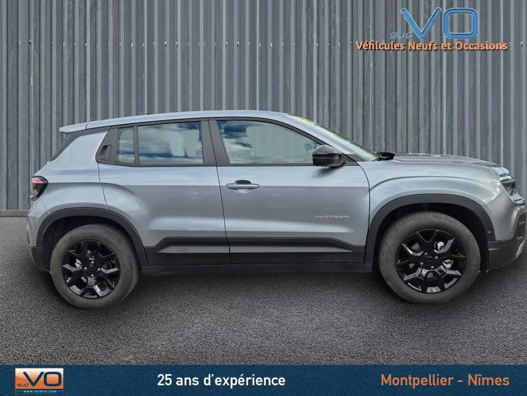 Profil côté gauche d'un Jeep Avenger gris foncé 2024 avec jantes noires et lignes épurées visibles.