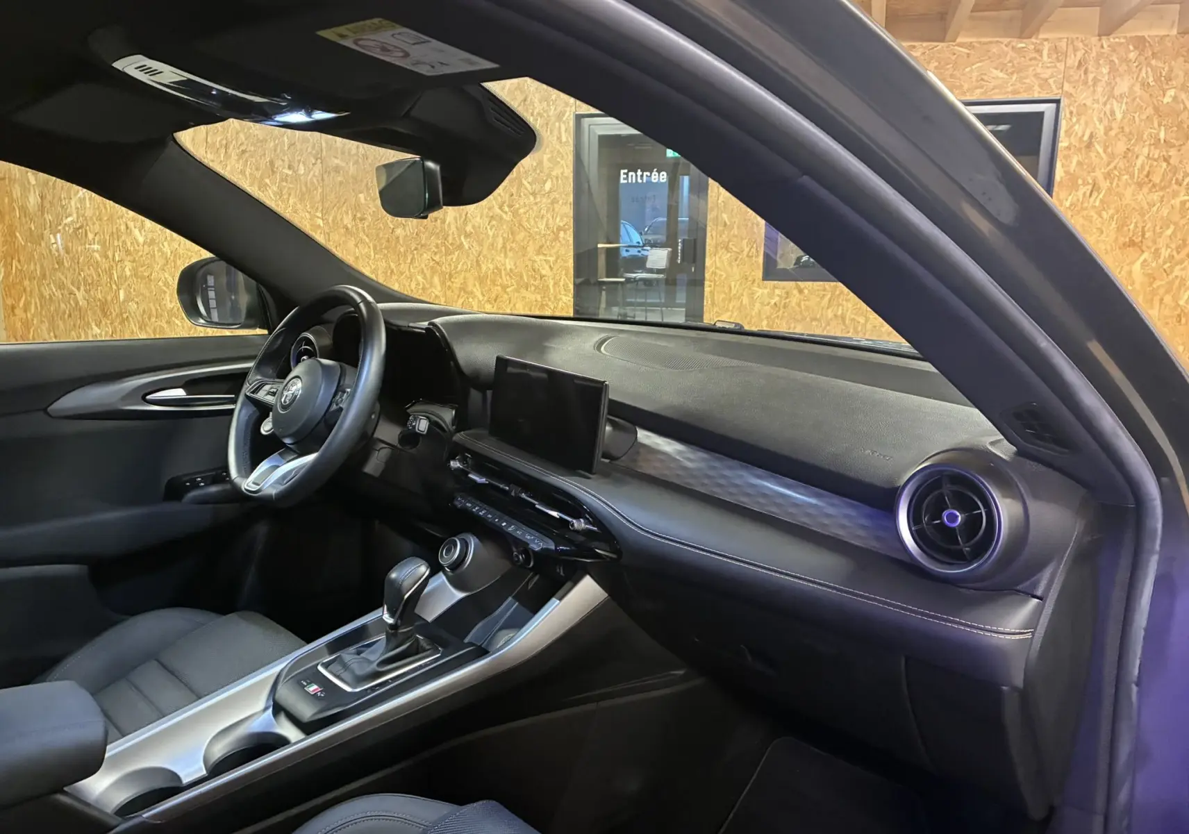 Intérieur noir de l'Alfa Romeo Tonale 1.3 PHEV 280 BVA TI, vue côté conducteur avec tableau de bord et écran central.