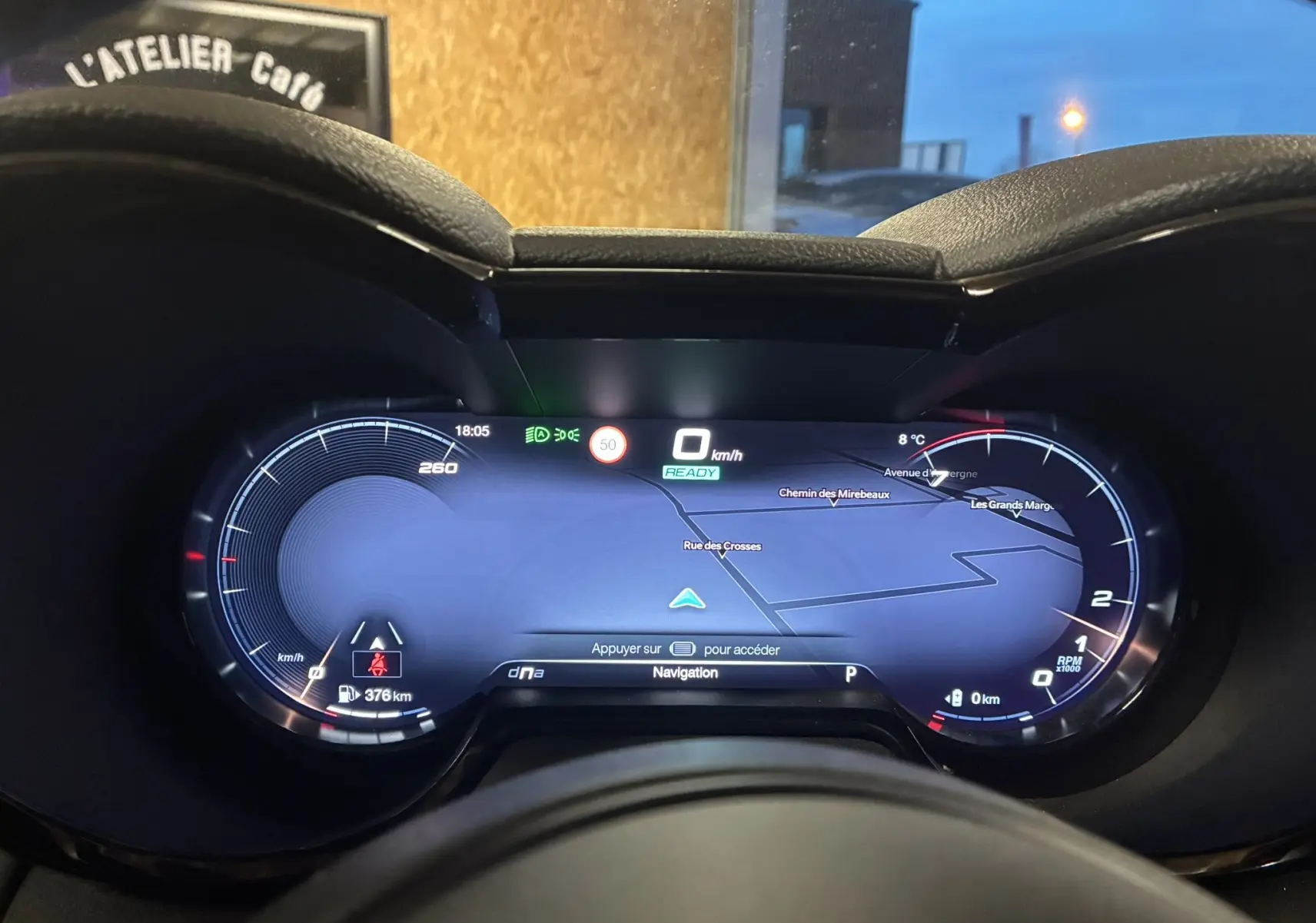 Vue rapprochée du tableau de bord numérique de l'Alfa Romeo Tonale 1.3 PHEV 280 BVA TI avec affichage de navigation et compteurs lumineux.