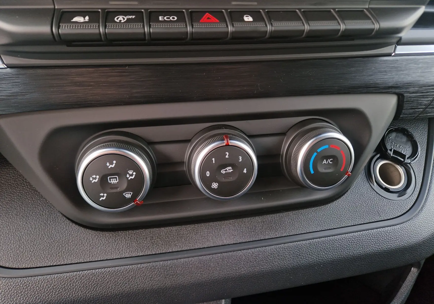 Gros plan sur les commandes de climatisation et boutons de fonction du tableau de bord du Nissan Primastar blanc, version 2025.