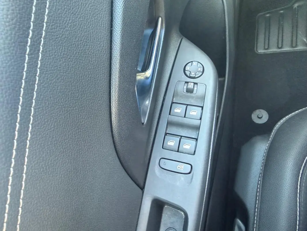 Vue rapprochée de la commande des vitres côté gauche sur porte intérieure noire de l’Opel Corsa rouge 2025.