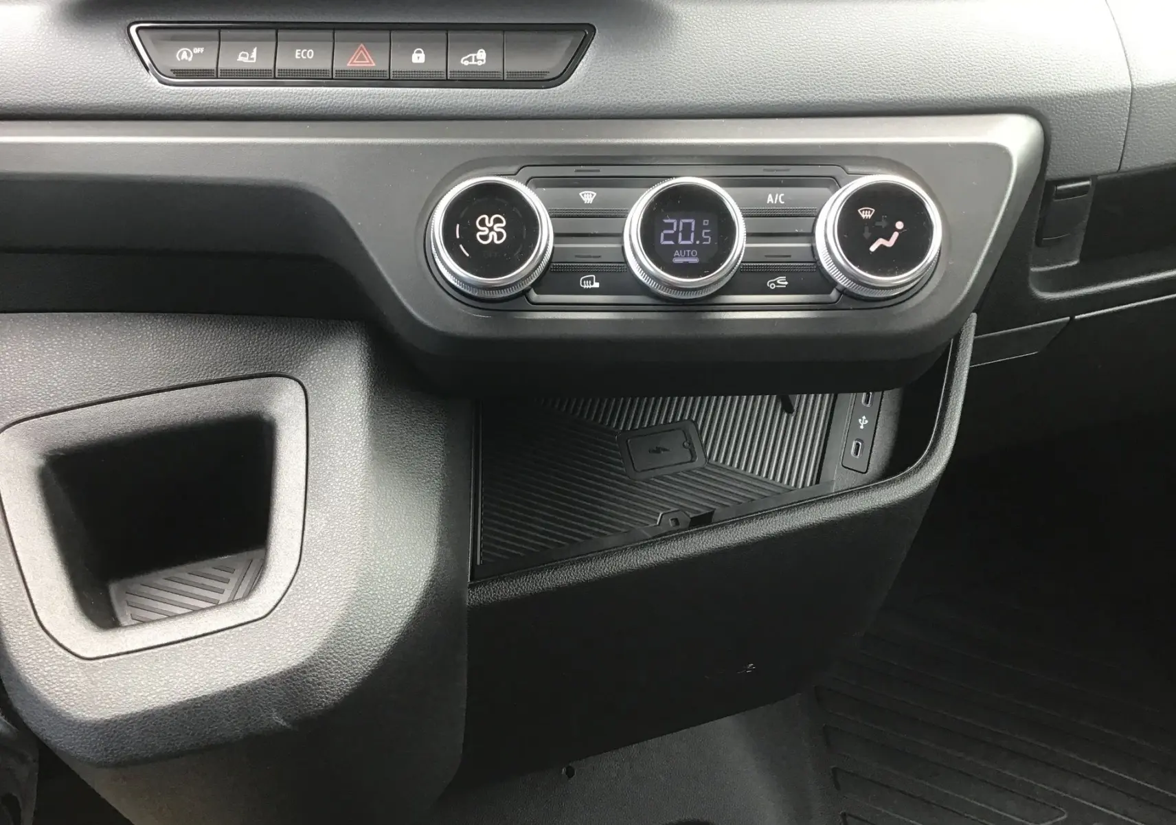 Vue rapprochée de la console centrale du Renault Master 2025 blanc, montrant les commandes de climatisation et un espace de rangement.