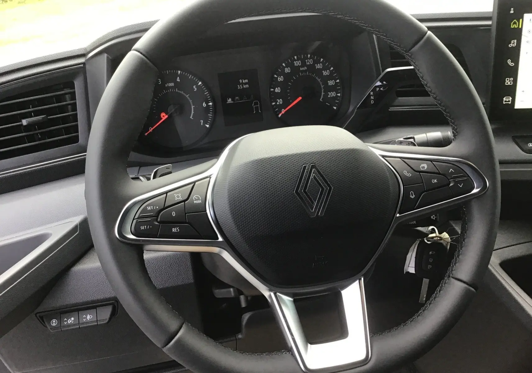 Vue rapprochée du volant noir du Renault Master 2025 avec commandes intégrées et tableau de bord digital.