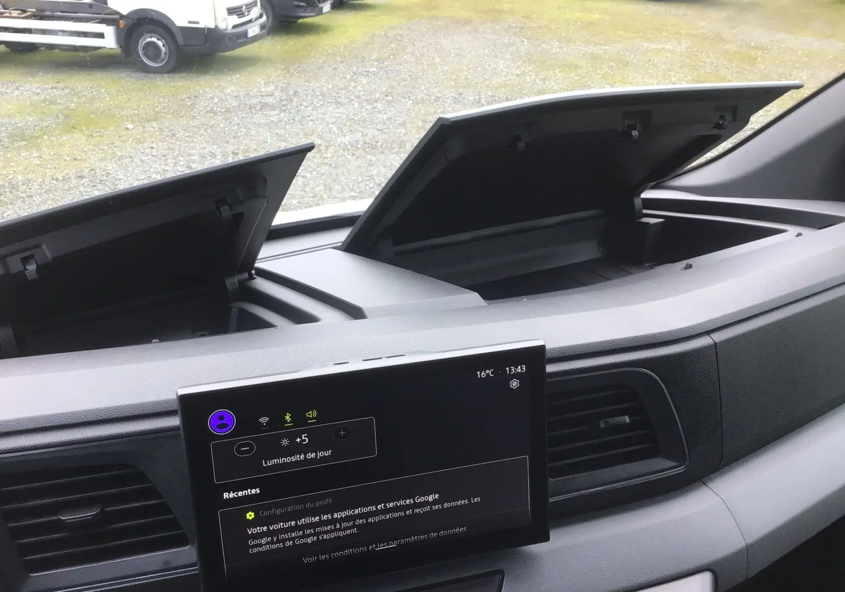 Vue intérieure du tableau de bord du Renault Master blanc 2025, avec double rangement ouvert et écran tactile central allumé.