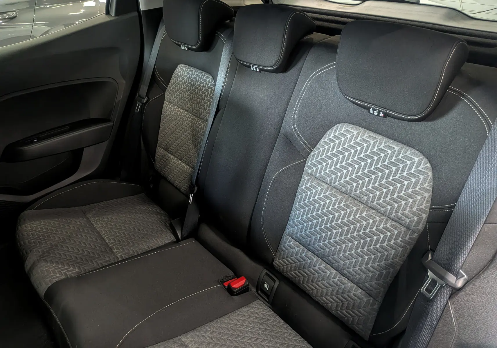 Vue intérieure des sièges arrière en tissu gris foncé avec motifs géométriques de la Renault Clio V TCe 100 CH GPL Evolution 2023.