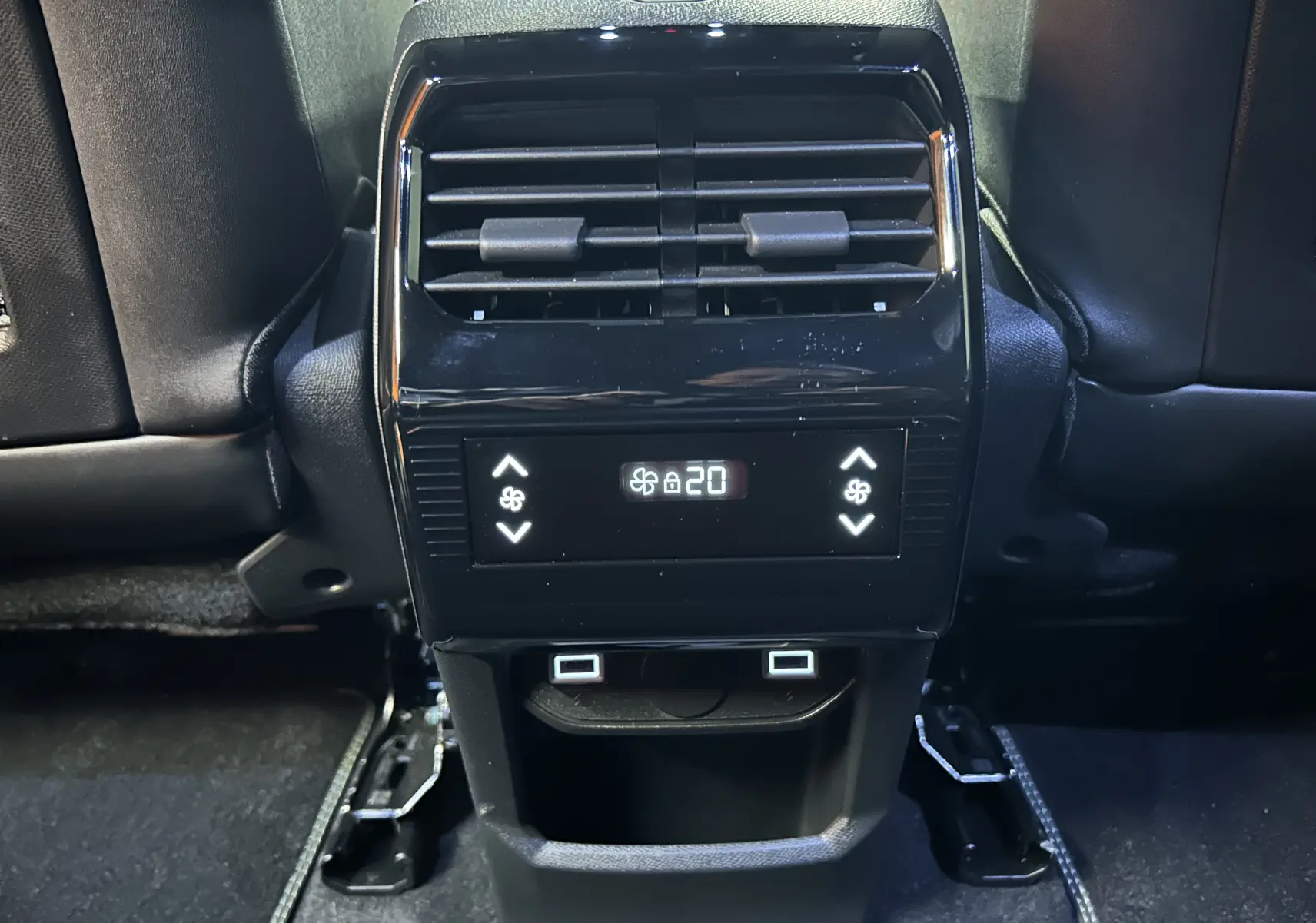 Vue rapprochée de la console arrière noire avec commandes de climatisation et prises USB du Peugeot 5008 gris titane.