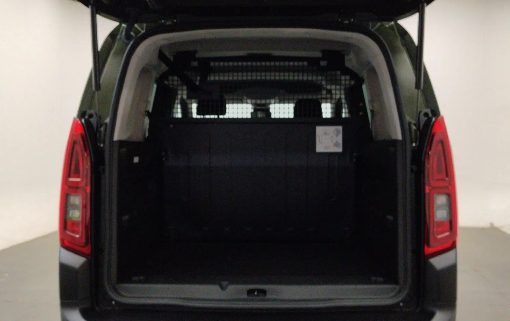 Vue arrière du Citroën Berlingo Multispace 2026 vert Sirkka avec porte arrière ouverte et cloison de séparation visible.