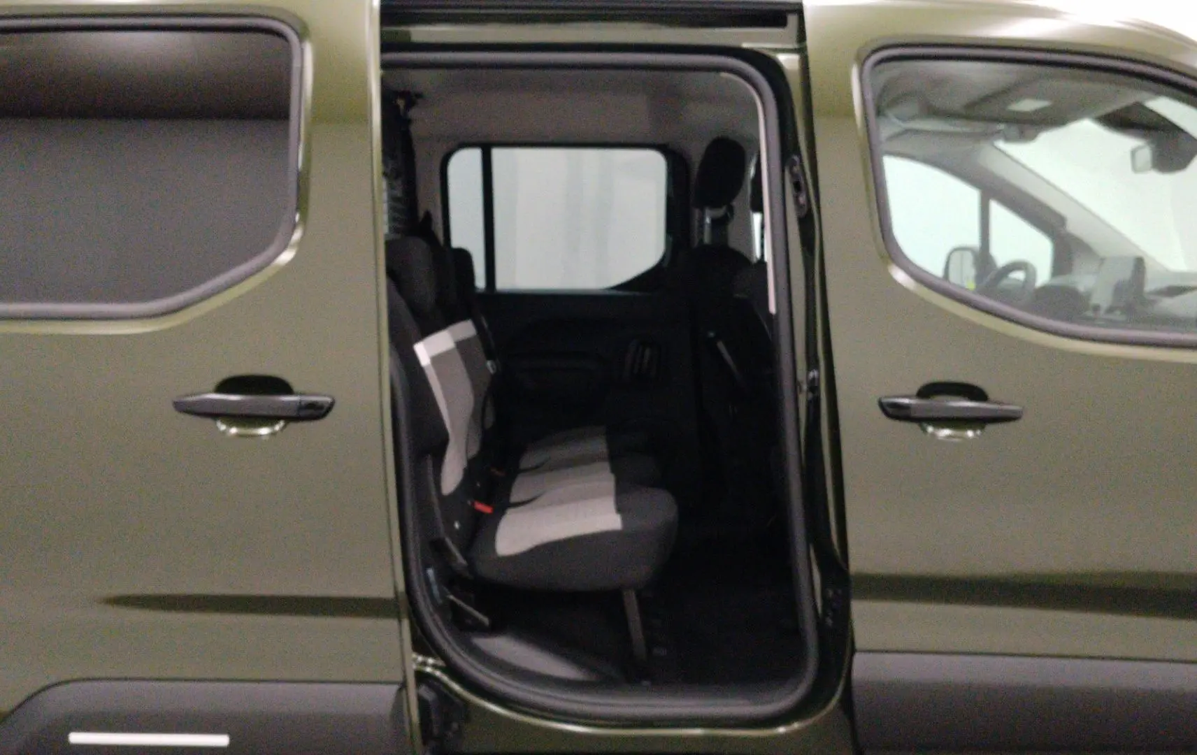 Vue latérale gauche du Citroën Berlingo Multispace 2026 Sirkka Green avec porte coulissante ouverte et sièges arrière visibles.
