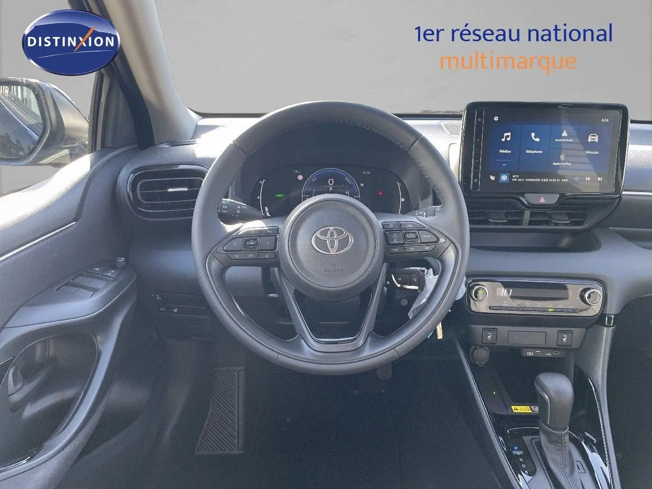 Intérieur de la Toyota Yaris Hybrid 116ch 2025, vue frontale du poste de conduite avec volant et écran tactile noir.