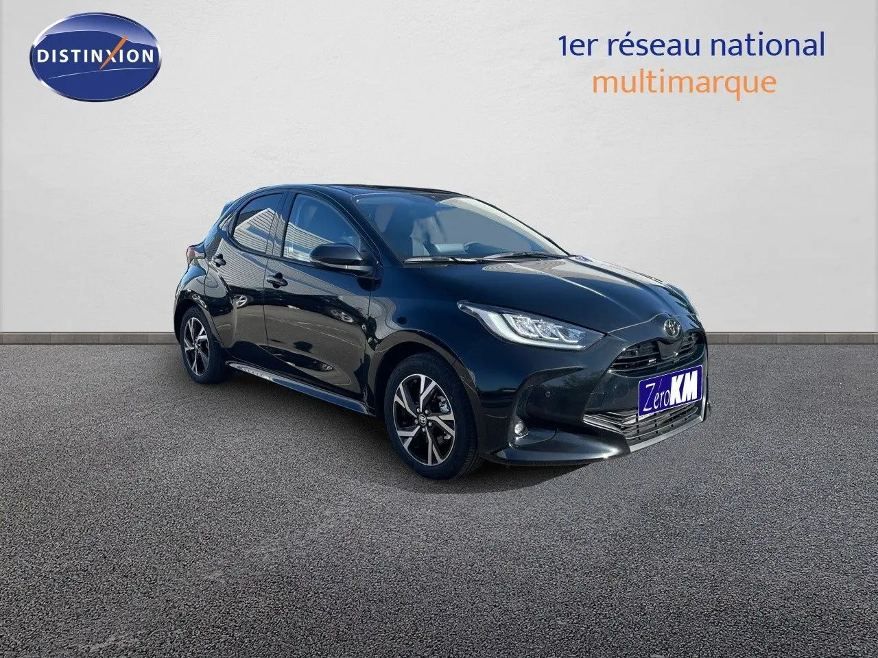 Toyota Yaris Hybrid 116ch noir métal vue 3/4 avant droit avec jantes bi-ton et phares LED allumés.