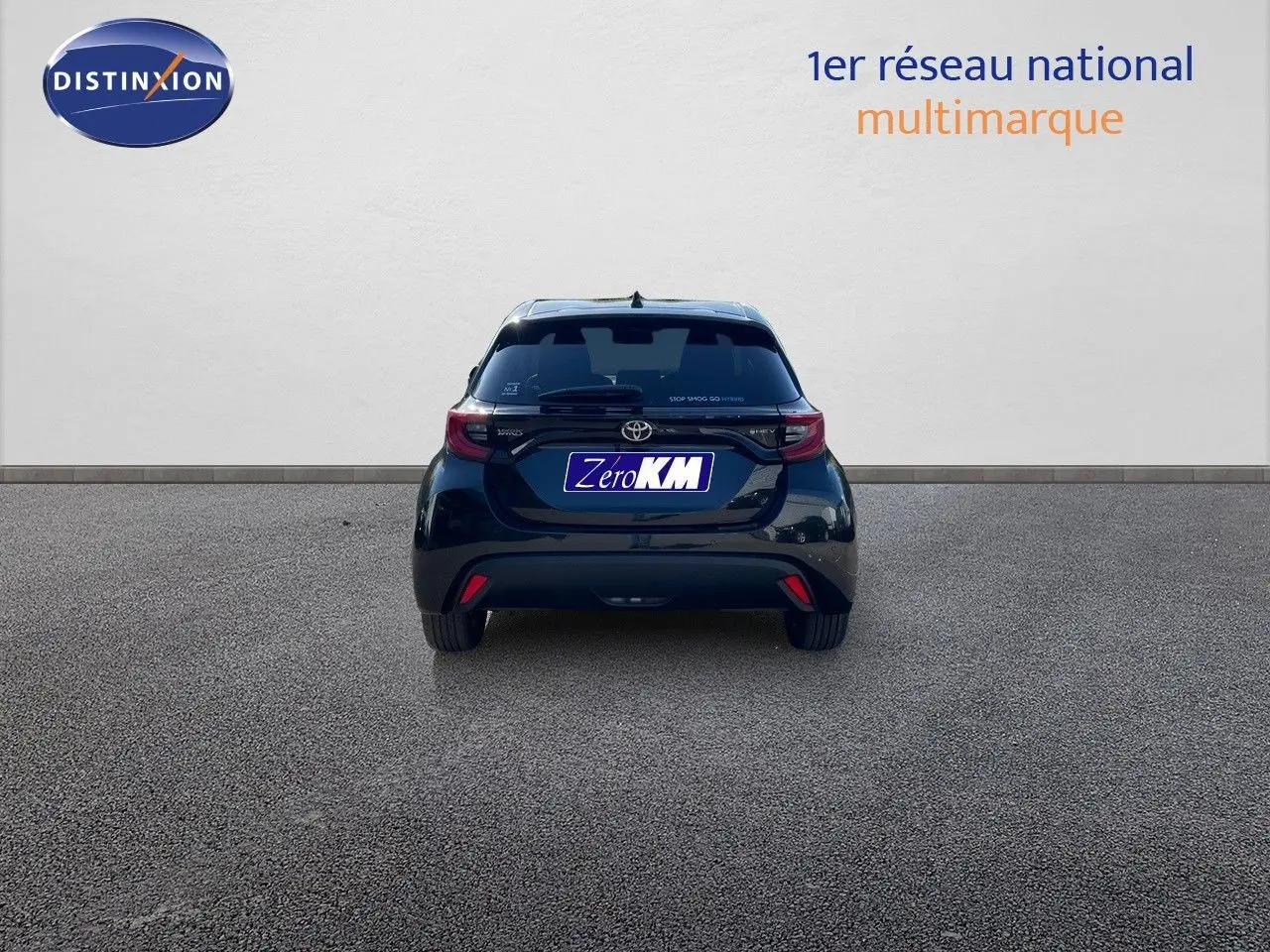 Vue arrière d'une Toyota Yaris Hybrid 116ch noire métal, avec feux arrière LED et logo distinctif sur hayon.