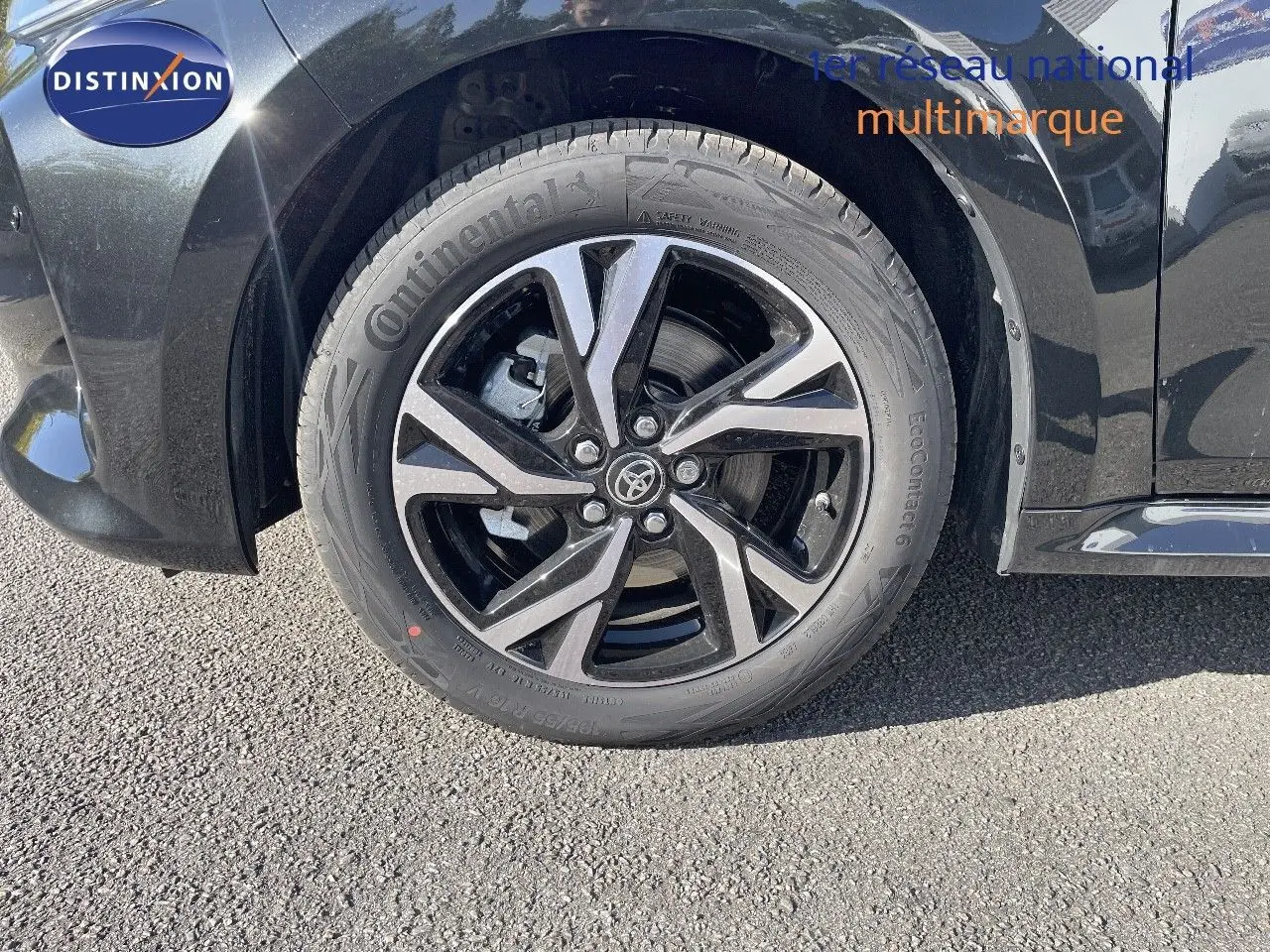 Gros plan sur la roue avant droite de la Toyota Yaris Hybrid 2025 noir métal avec jante alliage bicolore distinctive.