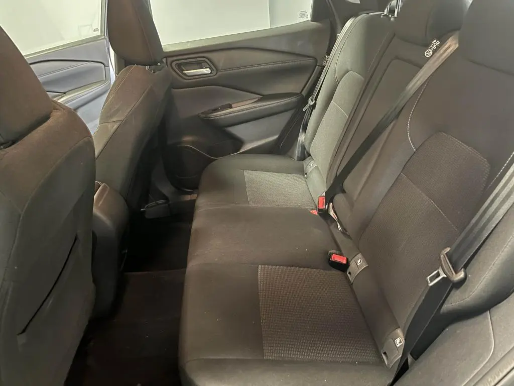 Vue côté droit de la banquette arrière noire en tissu du Nissan Qashqai 2023, avec ceintures de sécurité et appuie-têtes.