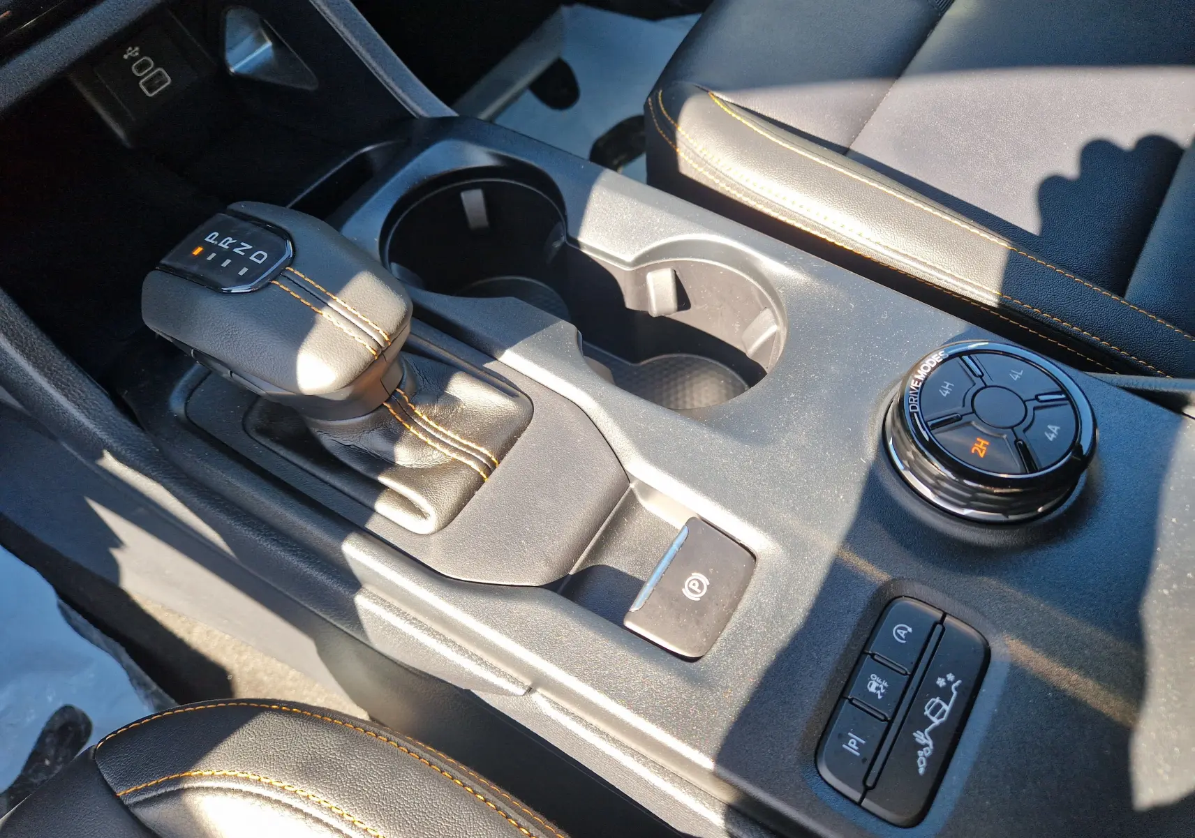 Gros plan sur la console centrale du Ford Ranger Wildtrak gris carbone, avec levier de vitesse et commandes de modes de conduite.