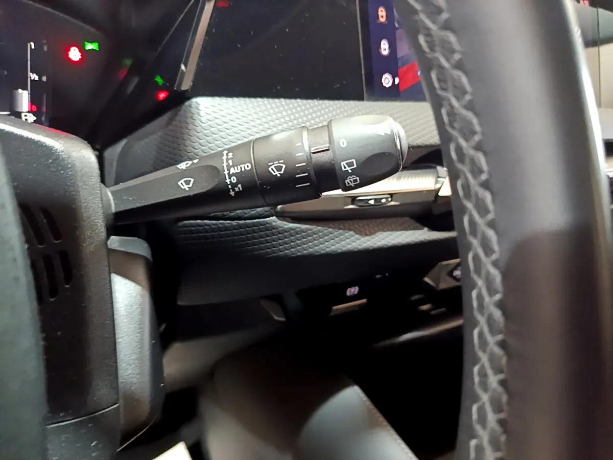 Gros plan sur la commande d’essuie-glace à gauche du volant cuir dans l’habitacle du DS4 E-TENSE gris foncé 2023.